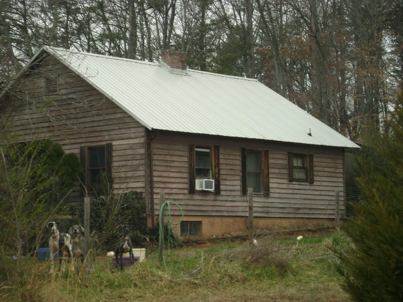 White metal roof on an old wood sided farmhouse, from a Metal Roof Installation job in Hooper